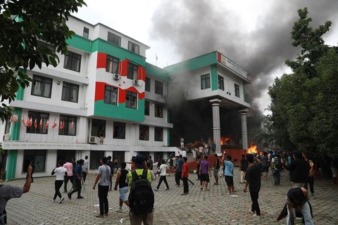 Para demonstran berkumpul di luar kantor Partai Kongres Nepal yang terbakar dalam aksi protes untuk mengecam tindakan keras polisi terhadap demonstran di Kathmandu, Selasa (9/09/2025).