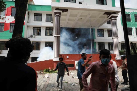 Para demonstran berkumpul di luar kantor Partai Kongres Nepal yang terbakar dalam aksi protes untuk mengecam tindakan keras polisi terhadap demonstran di Kathmandu, Selasa (9/09/2025).