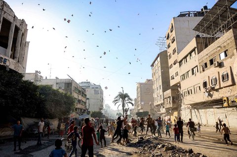 Warga menyaksikan selebaran yang dijatuhkan oleh militer Israel yang menyerukan evakuasi ke selatan menuju al-Mawasi di Kota Gaza, Selasa (09/09/2025).