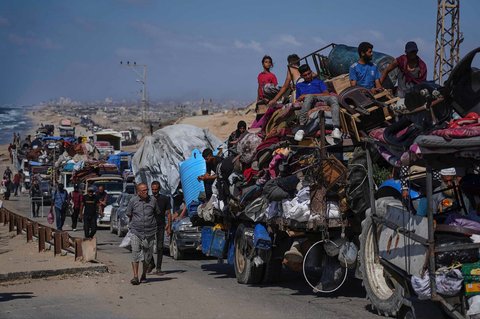 Warga Palestina yang mengungsi dari Gaza utara membawa barang-barang mereka di sepanjang jalan pesisir menuju Gaza selatan, Selasa (09/09/2025).