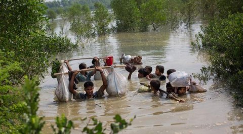 Anak-anak etnis Rohingya dari Myanmar merentangkan tangan mereka untuk menerima makanan yang didistribusikan oleh penduduk setempat di Kamp Pengungsian Kutupalong di Cox's Bazar, Bangladesh,