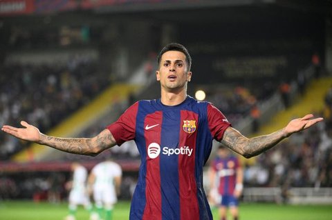 Pemain Barcelona, Joao Cancelo, mencetak gol ke gawang Real Betis pada laga Liga Spanyol di Estadi Olimpic Lluis Companys, Minggu (17/9/2023). Barca menang dengan skor 5-0. (AP Photo/Joan Mon