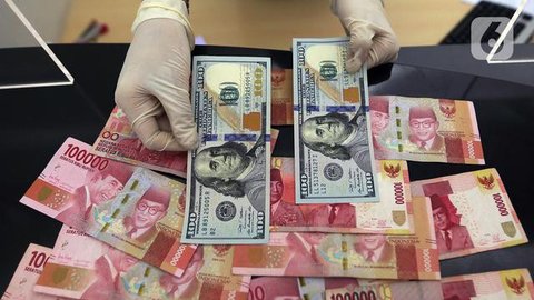 Petugas memperlihatkan uang pecahan US$100 dan rupiah di pusat penukaran uang, Jakarta, , Rabu (12/8/2015). Reshuffle kabinet pemerintahan Jokowi-JK, nilai Rupiah terahadap Dollar AS hingga s