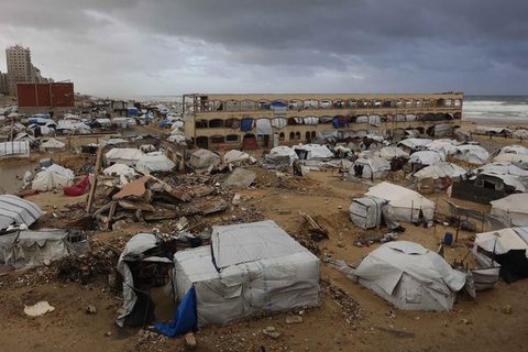 Dan kini tenda-tenda tersebut terpapar langsung massa udara kutub yang membawa suhu dingin ekstrem. Tampak dalam foto, seorang pria Palestina yang mengungsi memperbaiki tenda yang didirikan d