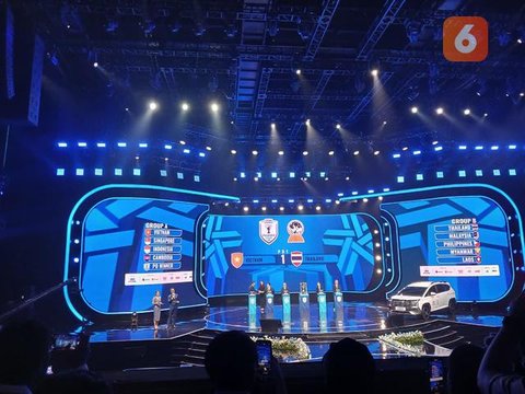 Ketua umum PSSI saat memegang kertas bertuliskan Malaysia dalam acara drawing ASEAN Championship 2026 di Studio RCTI Plus, Jakarta Barat, Kamis (15/1/2026). (Bola.com/Nur Iman Ali)