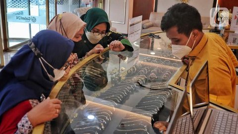 Seorang pelanggan mencoba gelang emas selama festival Hindu 'Akshaya Tritiya', hari keberuntungan dalam kalender Hindu untuk membeli barang-barang berharga, di ruang pamer perhiasan di Che
