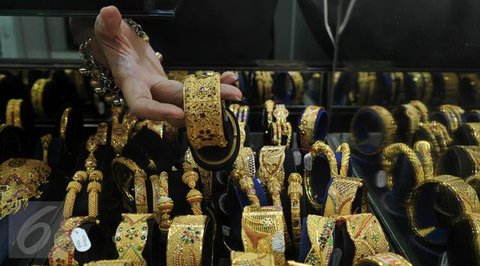 Seorang pelanggan mencoba gelang emas selama festival Hindu 'Akshaya Tritiya', hari keberuntungan dalam kalender Hindu untuk membeli barang-barang berharga, di ruang pamer perhiasan di Che
