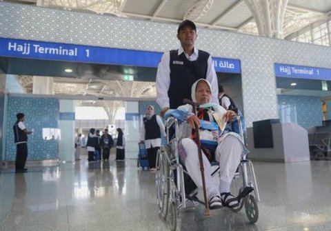 Salah seorang petugas sedang menggendong jemaah calon haji yang kelelahan. (www.kemenag.go.id)