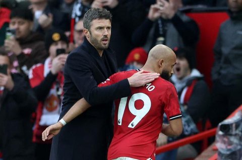 Suporter mengibarkan bendera dan membentangkan spanduk di tribun penonton selama pertandingan Premier League antara Manchester United dan Arsenal di Old Trafford, Manchester, Inggris barat
