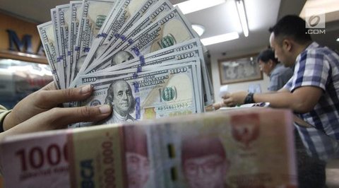 Karyawan menunjukkan uang rupiah dan dolar AS di Jakarta, Rabu (30/12/2020). Nilai tukar rupiah di pasar spot ditutup menguat 80 poin atau 0,57 persen ke level Rp 14.050 per dolar AS. (Liputa