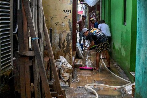 Genangan air tampak merendam beberapa ruas jalan utama, salah satunya Jalan Jembatan Tiga Raya di Jakarta Utara. Tampak dalam foto, pengendara terpaksa mendorong motornya yang mogok saat meli