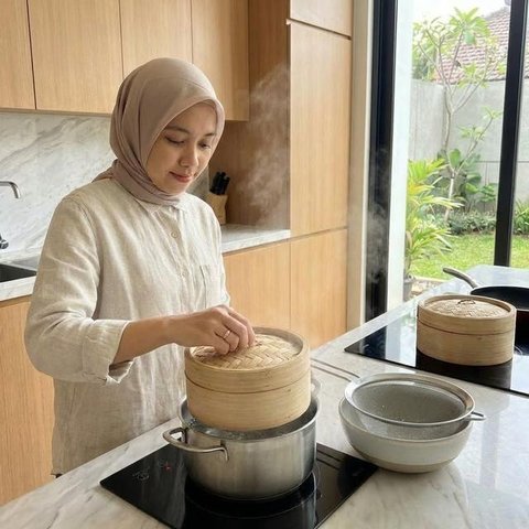 Mengocok telur merupakan salah satu tahapan memasak dengan resep telur tahu kukus lembut (Gemini AI)