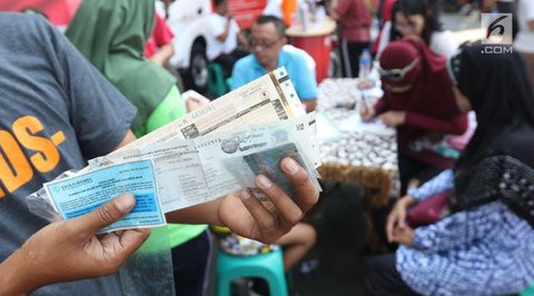 Warga membayar pajak kendaraan bermotor di samsat keliling di car free day, Jakarta, Minggu (27/8). Layanan pembayaran pajak Surat Tanda Nomor Kendaraan (STNK) bisa dilakukan tanpa membawa sa