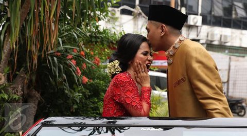 Sementara itu, Santi tampil memikat dalam balutan kebaya putih dengan detail bordir halus. Siluet kebaya yang ringan berpadu dengan kain bernuansa lembut, menghadirkan tampilan pengantin yang