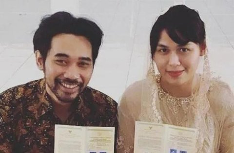Sementara itu, Santi tampil memikat dalam balutan kebaya putih dengan detail bordir halus. Siluet kebaya yang ringan berpadu dengan kain bernuansa lembut, menghadirkan tampilan pengantin yang