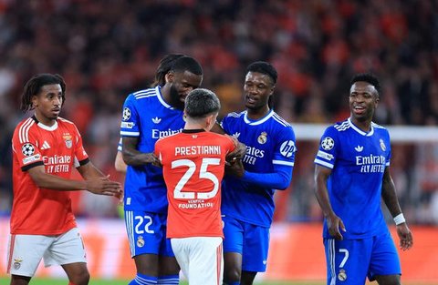Vinicius Junior (kanan) mencetak gol tunggal kemenangan Real Madrid atas Benfica pada laga leg pertama knockout play-off Liga Champions musim ini di Estadio da Luz, Lisbon, Rabu (18/02/2026) dini hari WIB. Sayangnya dalam duel tersebut, Vincius menjadi korban tindakan rasisme yang dilakukan pendukung dan pemain Benfica, Gianluca Prestianni. (AFP/PATRICIA DE MELO MOREIRA)