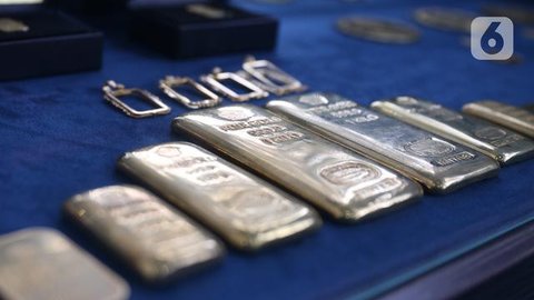 Seorang karyawan menunjukkan emas batangan 25, 50, dan 100 gram produksi Galeri 24, anak perusahaan dari PT Pegadaian (Persero), di Jakarta pada 14 April 2025. (BAY ISMOYO/AFP)
