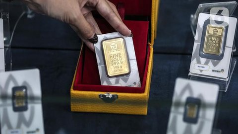 Petugas menunjukkan sampel logam mulia di Butik Emas Antam, Jakarta, Kamis, (23/7/2020). Usai cetak rekor ke posisi termahalnya di Rp 982 ribu, harga emas PT Aneka Tambang Tbk (Emas Antam) ke