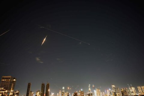 Orang-orang menyaksikan kepulan asap membubung di langit Teheran, Iran, setelah terjadinya ledakan, Sabtu (28/2/2026) akibat serangan Israel dan Amerika Serikat. (Dok. AP)