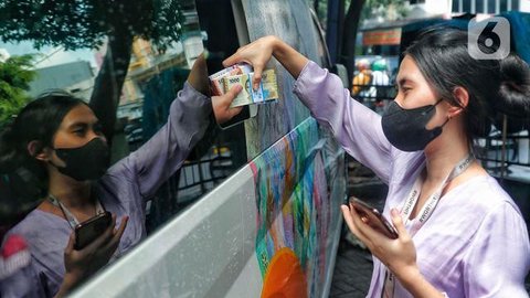 Warga menukarkan uang tunai baru di layanan kas keliling Bank Indonesia di Pasar Kopro, Jakarta Barat, Rabu (29/3/2023). (Liputan6.com/Angga Yuniar)