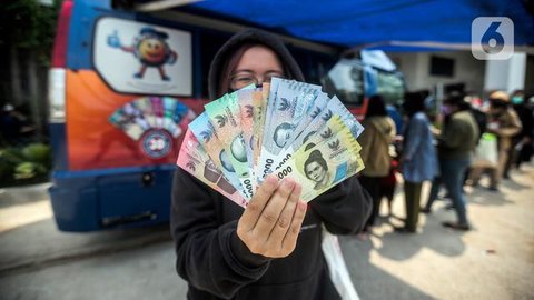 Warga menukarkan uang tunai baru di layanan kas keliling Bank Indonesia di Pasar Kopro, Jakarta Barat, Rabu (29/3/2023). (Liputan6.com/Angga Yuniar)