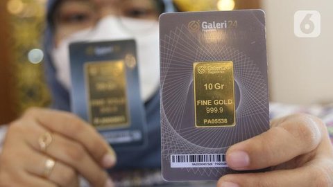 Seorang petugas menunjukkan koleksi emas batangan di Galeri 24 Pegadaian, Jakarta, Jumat (25/3/2022). Harga emas Antam di Pegadaian kembali naik. Hari ini harga emas Antam naik Rp 6.000 menja