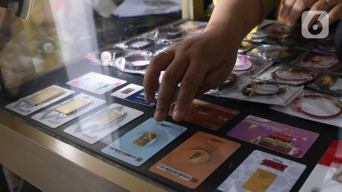 Seorang petugas menunjukkan koleksi emas batangan di Galeri 24 Pegadaian, Jakarta, Jumat (25/3/2022). Harga emas Antam di Pegadaian kembali naik. Hari ini harga emas Antam naik Rp 6.000 menja