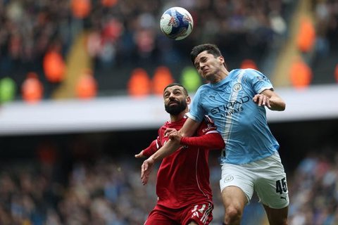 Mohamed Salah berebut bola dengan Abdukodir Khusanov dalam laga FA Cup antara Manchester City vs Liverpool di Etihad Stadium, 4 April 2026. (AFP/Darren Staples)