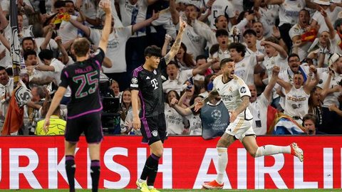 Kiper Bayern Munchen, Manuel Neuer (kiri) berhasil menangkap bola tendangan striker Real Madrid, Rodrygo (tengah) pada laga leg kedua semifinal Liga Champions 2023/2024 di Santiago Bernabeu S