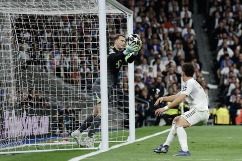Momen striker Bayern Munchen Harry Kane melakukan shooting ke gawang Real Madrid yang dikawal Andriy Lunin. (Oscar DEL POZO / AFP)