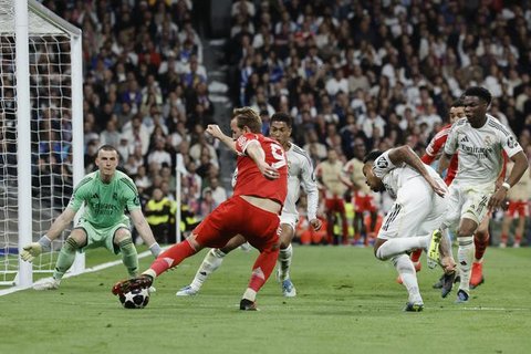 Momen striker Bayern Munchen Harry Kane melakukan shooting ke gawang Real Madrid yang dikawal Andriy Lunin.