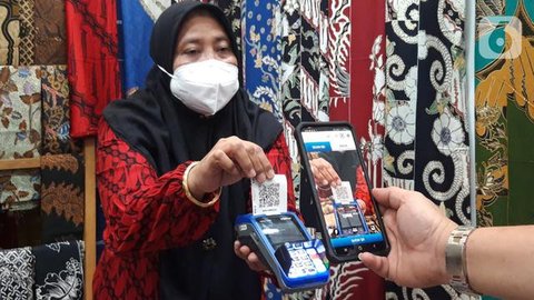 Pengunjung melakukan transaksi menggunakan QR Code BCA mobile pada pameran Adi Wastra Nusantara di Jakarta (11/2/2022). Ketiga pilar utama diimplementasikan pada pameran Adi Wastra Nusantara