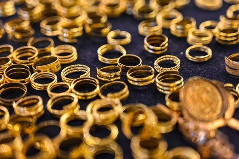 Seorang penjual berjalan melewati kalung emas yang dipajang selama festival Hindu 'Akshaya Tritiya', hari keberuntungan dalam kalender Hindu untuk membeli barang-barang berharga, di ruang