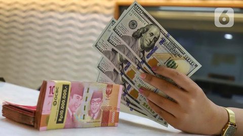 Petugas memperlihatkan uang pecahan US$100 dan rupiah di pusat penukaran uang, Jakarta, , Rabu (12/8/2015). Reshuffle kabinet pemerintahan Jokowi-JK, nilai Rupiah terahadap Dollar AS hingga s