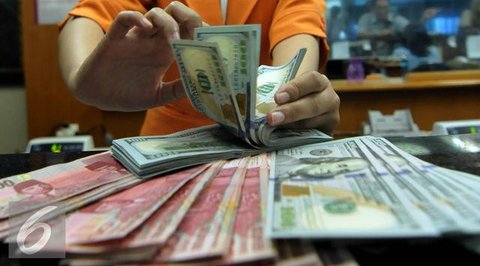 Petugas memperlihatkan uang pecahan US$100 dan rupiah di pusat penukaran uang, Jakarta, , Rabu (12/8/2015). Reshuffle kabinet pemerintahan Jokowi-JK, nilai Rupiah terahadap Dollar AS hingga s