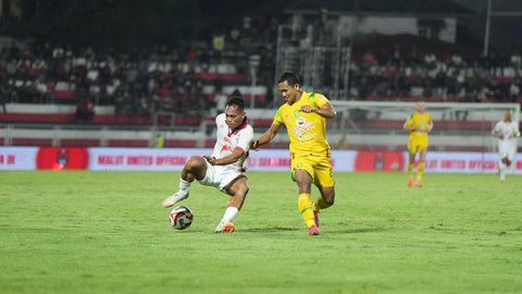 Gelandang Persebaya, Pedro Matos (kanan) mencoba mengecoh gelandang Malut United, Taufik Rustam dalam laga pekan ke-29 BRI Super League 2025/2026 di Stadion Gelora Kie Raha, Ternate, Maluku U
