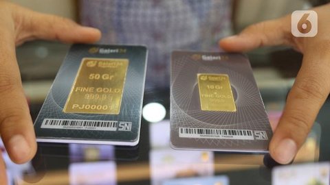 Seorang petugas menunjukkan koleksi emas batangan di Galeri 24 Pegadaian, Jakarta, Jumat (25/3/2022). Harga emas Antam di Pegadaian kembali naik. Hari ini harga emas Antam naik Rp 6.000 menja