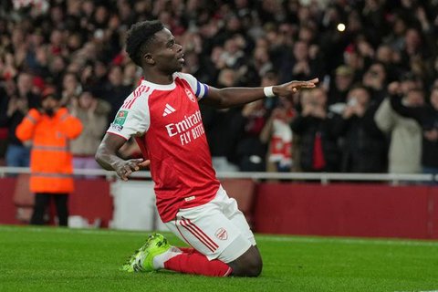 Gelandang Arsenal asal Inggris #07, Bukayo Saka, merayakan gol kedua tim dari titik penalti dalam pertandingan Premier League antara Arsenal dan West Ham United di Stadion Emirates, London