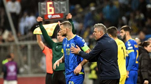 Striker Timnas Bosnia-Herzegovina, Edin Dzeko, mengenakan jersey biru produksi Kelme di laga Kualifikasi Euro 2024. (ELVIS BARUKCIC / AFP)