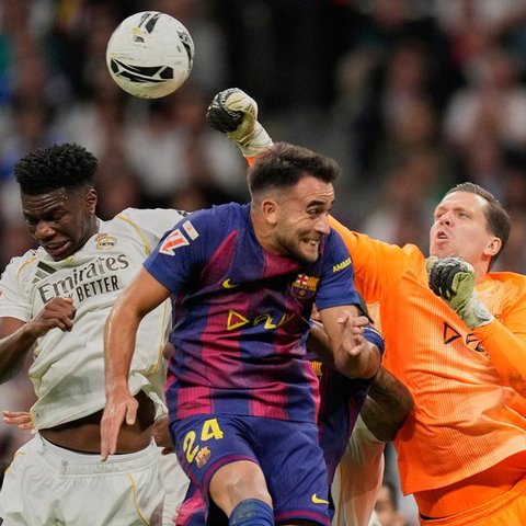 Kiper Barcelona, Wojciech Szczesny, meninju bola melewati Aurelien Tchouameni dari Real Madrid dan Eric Garcia dari Barcelona dalam pertandingan La Liga di Santiago Bernabeu, Minggu, 26 Oktober 2025.