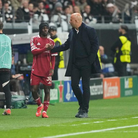 Arne Slot bersalaman dengan Jeremie Frimpong saat pergantian pemain dalam laga Liga Champions antara Eintracht Frankfurt dan Liverpool di Frankfurt, Jerman, 23 Oktober 2025.