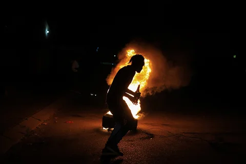 Seorang pemuda berlari melewati ban yang terbakar saat perayaan malam tahun baru di Zona 7 kota Sebokeng, selatan Johannesburg, Afrika Selatan, Kamis (01/01/2026).