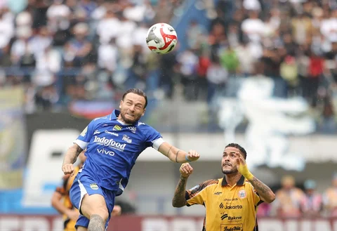 Pemain Persib Bandung, Marc Klok (kiri), terlibat dalam perebutan bola dengan pemain persija Maxwell pada pertandingan BRI Super League 2025/2026 yang berlangsung di Stadion Gelora Bandung Lautan Api, Bandung, Minggu (11/01/2026).