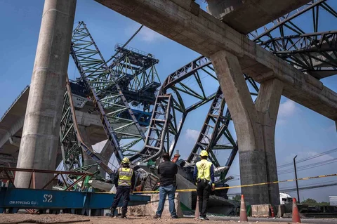 Para pekerja penyelamat berdiri di lokasi runtuhnya derek konstruksi di jalan raya di Samut Sakhon, pinggiran Bangkok, Kamis (15/01/2026).