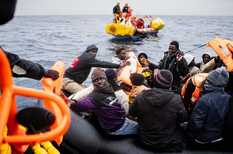 Para migran di atas perahu karet menerima jaket pelampung saat kru kapal penyelamat Ocean Viking melakukan operasi penyelamatan menggunakan RHIB (Rigid Inflatable Boat) di zona pencarian dan penyelamatan di lepas perairan internasional Libya, Jumat (16/01/2026).