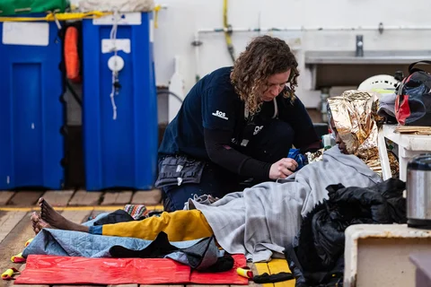 Para migran  diperiksa paramedis usai dinaikkan ke atas  kapal penyelamat Ocean Viking saat operasi penyelamatan di zona pencarian dan penyelamatan di lepas perairan internasional Libya, Jumat (16/01/2026).