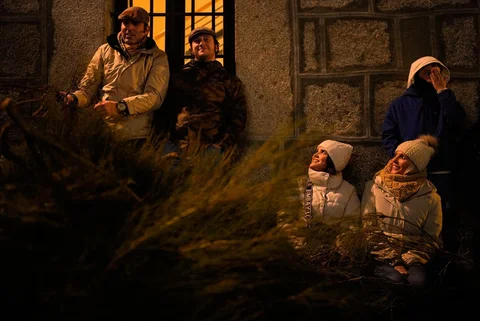 Pengunjung menunggu di samping semak-semak yang akan dibakar sebagai bagian dari ritual untuk menghormati Santo Antonius sang Abbas, santo pelindung hewan peliharaan, di San Bartolome de Pinares, Spanyol, Jumat (16/01/2026).