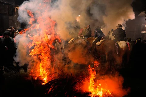 Para penunggang kuda menunggu untuk melompati api unggun sebagai bagian dari ritual untuk menghormati Santo Antonius sang Abbas, santo pelindung hewan peliharaan, di San Bartolome de Pinares, Spanyol, Jumat (16/01/2026).