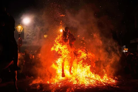 Para penunggang kuda melompati api unggun sebagai bagian dari ritual untuk menghormati Santo Antonius sang Abbas, santo pelindung hewan peliharaan, di San Bartolome de Pinares, Spanyol, Jumat (16/01/2026).