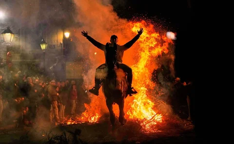 Para penunggang kuda melompati api unggun sebagai bagian dari ritual untuk menghormati Santo Antonius sang Abbas, santo pelindung hewan peliharaan, di San Bartolome de Pinares, Spanyol, Jumat (16/01/2026).